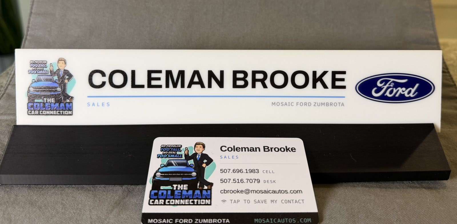 Printed acrylic desk nameplate on a black stand, with a matching contactless card leaning against it