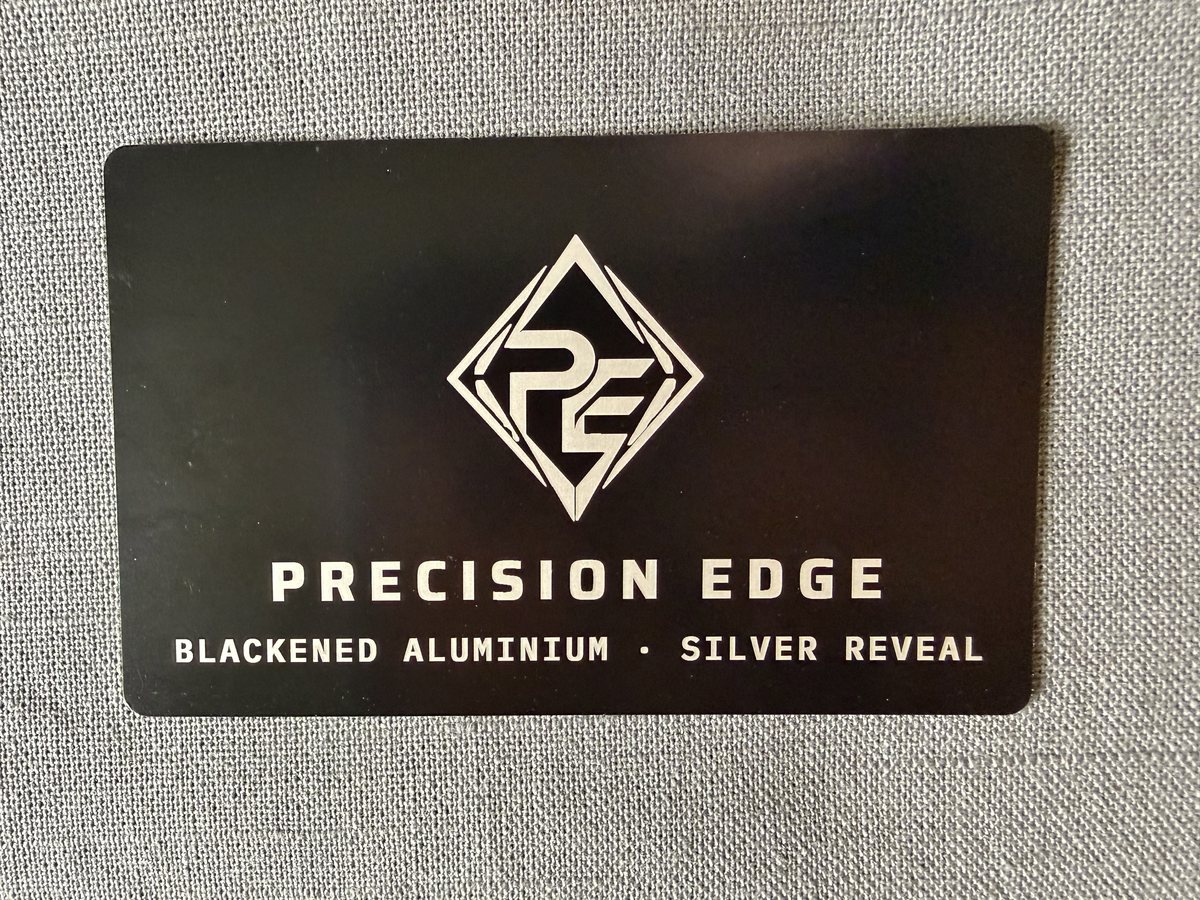 Precision Edge card in blackened aluminum, logo laser-engraved to a bright silver reveal
